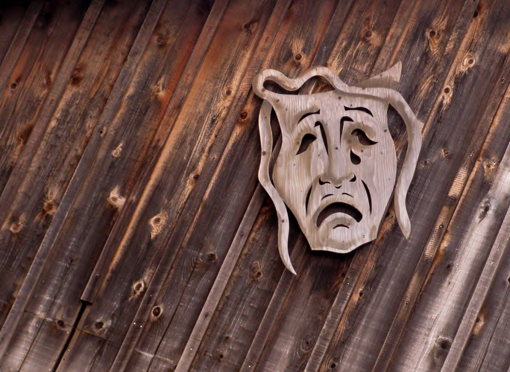 Tragedy theatrical mask on wooden background